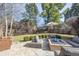Cozy backyard with stone patio and comfortable seating around a fire pit and an open grassy area at 374 Holly St, Denver, CO 80220