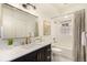 Modern bathroom with chic vanity and stylish fixtures, combined bath and shower with a tiled surround at 374 Holly St, Denver, CO 80220