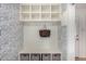 This entryway has an alcove with shelves, a storage bench with drawers, and blue patterned wallpaper at 374 Holly St, Denver, CO 80220