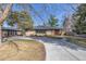 Charming brick ranch-style home with a circular driveway and mature trees on a sunny day at 374 Holly St, Denver, CO 80220