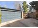 A two-car garage with a concrete driveway and wood fence alongside at 374 Holly St, Denver, CO 80220