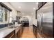 Sleek kitchen featuring stainless steel appliances, dark cabinetry, and ample counter space at 374 Holly St, Denver, CO 80220