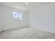 A bright, carpeted bedroom with a large window that provides ample natural light at 13708 Daffodil Pt, Parker, CO 80134