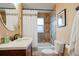 Basement bathroom with tub, shower, and updated vanity at 6653 N Knox Ct, Denver, CO 80221