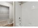 Clean bathroom with white tiled shower, linen closet, and neutral-toned walls at 48229 Shetland Dr, Bennett, CO 80102
