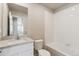 Clean bathroom featuring a white vanity, ample mirror, toilet, and tub with white subway tile surround at 48229 Shetland Dr, Bennett, CO 80102