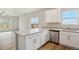 Eat-in kitchen with gray counters, white cabinets, stainless steel dishwasher, and hardwood-style floors at 48229 Shetland Dr, Bennett, CO 80102