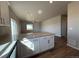 This kitchen features a large island, white cabinetry, stainless steel appliances, and wood-look flooring at 48229 Shetland Dr, Bennett, CO 80102
