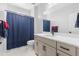 Bright bathroom featuring a modern vanity, a toilet, and a blue shower curtain for a clean, modern design at 11000 Shining Star Cir, Parker, CO 80134