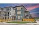 Stylish three-story home with muted-blue siding and wooden fence under a gorgeous pink and blue sky at 11000 Shining Star Cir, Parker, CO 80134