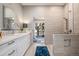 Spa-like bathroom featuring stone tiling, a walk-in shower with a bench, and a modern white vanity at 14707 E Wagon Trail Dr, Aurora, CO 80015