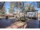 Outdoor seating area with a wooden deck, a projector screen, beautiful pine trees and other greenery at 14707 E Wagon Trail Dr, Aurora, CO 80015