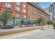 Street view of a beautiful brick apartment building with storefronts and residences, showcasing urban living at 1555 California St # 304, Denver, CO 80202
