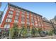 Exterior of a red brick building with many windows and a blue sky backdrop at 1555 California St # 304, Denver, CO 80202