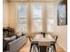 Bright living room area with hardwood floors, three large windows, and dining table at 1555 California St # 304, Denver, CO 80202