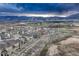 A wide angle aerial view of a residential neighborhood nestled amongst mountains under a cloudy sky at 1734 Peak Prairie Ln, Monument, CO 80132