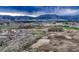 Expansive aerial view of a neighborhood with mountains under a dramatic sky at 1734 Peak Prairie Ln, Monument, CO 80132