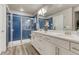 Modern bathroom with glass enclosed shower, double sinks, and a white vanity at 1734 Peak Prairie Ln, Monument, CO 80132