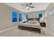 Bedroom featuring three large windows, ceiling fan, lamps, bedside tables, and a bed at 1734 Peak Prairie Ln, Monument, CO 80132