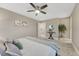 Light-filled bedroom with carpet, ceiling fan, a decorative plant, and an en-suite bathroom at 1734 Peak Prairie Ln, Monument, CO 80132