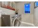 Functional laundry room featuring a new washer and dryer and a window to the outside at 1734 Peak Prairie Ln, Monument, CO 80132