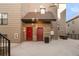Back exterior view with a red door, tan siding, and an industrial-style metal trash receptacle and grill at 3069 Tejon St # B, Denver, CO 80211
