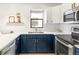 Close-up of modern kitchen featuring stainless steel appliances, white countertops, and navy blue cabinets at 3069 Tejon St # B, Denver, CO 80211