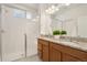 Elegant bathroom boasts double sinks with granite countertops and a tiled glass-door shower at 6153 N Ceylon St # 203, Denver, CO 80249