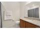 Bathroom with granite countertop, wood vanity, toilet, and shower/tub with black and white curtain at 6153 N Ceylon St # 203, Denver, CO 80249