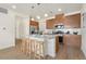Kitchen area with stainless steel refrigerator, wood cabinets and granite counters and three barstools at 6153 N Ceylon St # 203, Denver, CO 80249