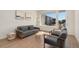 Bright living room with two gray chairs, a gray sofa, wood floors and large windows at 6153 N Ceylon St # 203, Denver, CO 80249