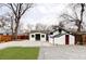 Well-maintained backyard with lush artificial grass, stone patio, and a quaint storage shed at 2252 Harlan St, Edgewater, CO 80214