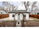 Charming home featuring a white exterior, gray door, and decorative wrought iron fence and gate at 2252 Harlan St, Edgewater, CO 80214