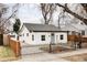 View of a cozy home with a white exterior, gray trim, and a decorative black wrought iron fence at 2252 Harlan St, Edgewater, CO 80214