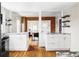 Bright kitchen featuring white cabinets, granite countertops, and hardwood floors open to dining area at 2252 Harlan St, Edgewater, CO 80214