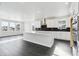 Modern kitchen features white cabinets, stainless steel appliances, an island with a marble countertop, and hardwood floors at 5566 Hickory Oaks Trl, Castle Rock, CO 80104