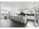 Spacious white kitchen with modern appliances, a large island with bar seating, and sleek black countertops at 5566 Hickory Oaks Trl, Castle Rock, CO 80104
