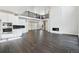 Spacious living room with hardwood floors, a fireplace, and white cabinets in the connected kitchen at 5566 Hickory Oaks Trl, Castle Rock, CO 80104