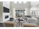 Cozy living room with a large sectional sofa, fireplace, and expansive windows offering neighborhood views at 5566 Hickory Oaks Trl, Castle Rock, CO 80104