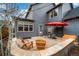 Cozy backyard patio with Adirondack chairs, table with umbrella, and gray siding at 84 Inca St, Denver, CO 80223