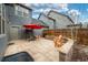 Backyard patio featuring stone pavers, a grill, and seating with a red umbrella at 84 Inca St, Denver, CO 80223