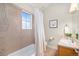 Bathroom with tan tiling, a shower-tub combination, and a bright window at 84 Inca St, Denver, CO 80223