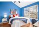 Bright bedroom featuring blue walls, hardwood floors, and a large window for natural light at 84 Inca St, Denver, CO 80223