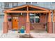 Inviting front porch with a cozy swing, brick pillars, and a vibrant flower arrangement at 84 Inca St, Denver, CO 80223