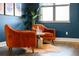Stylish living area featuring two orange chairs, hardwood floors, and lots of natural light at 84 Inca St, Denver, CO 80223