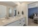 Bright bathroom featuring a dual sink vanity with a neutral countertop and a peek into the primary bedroom at 2538 Ambience Ln, Castle Rock, CO 80109