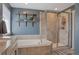 Bathroom featuring a soaking tub with a tiled shower, open shelves, and neutral paint at 2538 Ambience Ln, Castle Rock, CO 80109