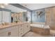 Luxurious primary bathroom with double vanity, soaking tub, a tiled shower and modern finishes at 2538 Ambience Ln, Castle Rock, CO 80109