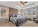 Bright bedroom with a wood accent wall, a ceiling fan, and large windows for plenty of natural light at 2538 Ambience Ln, Castle Rock, CO 80109