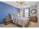 Comfortable bedroom with a wood accent wall, ceiling fan, and neutral-toned bedding at 2538 Ambience Ln, Castle Rock, CO 80109